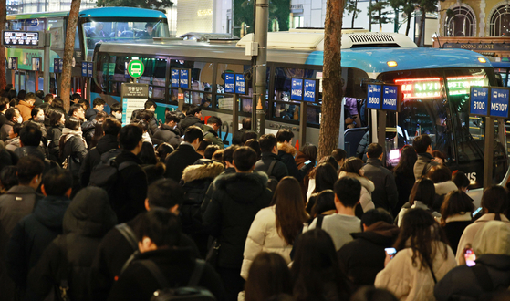 지난 4일 저녁 서울 명동에서 시민들이 퇴근을 하기 위해 버스를 기다리고 있다. 서울시는 지난달 28일 시민 안전을 고려해 명동입구 정류장에 노선 표시 시설물을 설치했다. 하지만 30여개에 달하는 광역버스가 정해진 위치에 정차해 승객을 태우려고 길게 늘어서며 교통 체증이 더 심해졌다는 지적이 나오고 있다. 〈사진=연합뉴스〉