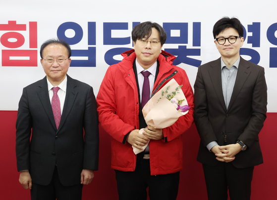 8일 국회에서 열린 국민의힘 입당 및 영입 환영식에서 한동훈 비상대책위원장과 윤재옥 원내대표가 학교폭력 전문 변호사인 박상수 변호사에게 당 점퍼를 입혀주고 기념촬영을 하고 있다. 〈사진=연합뉴스〉