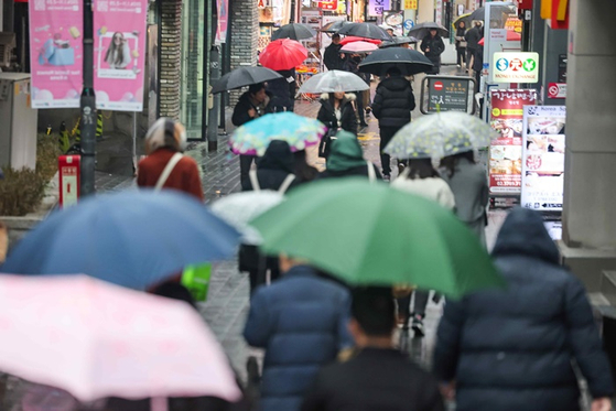 서울 중구 명동거리에서 시민들이 우산을 쓰고 이동하고 있다. 〈사진=연합뉴스〉