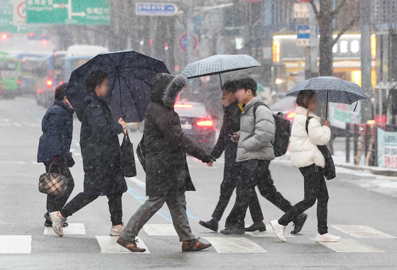 지난 9일 오전 서울 중구 을지로입구역 인근에서 시민들이 눈을 맞으며 출근하고 있다. 〈사진=연합뉴스〉