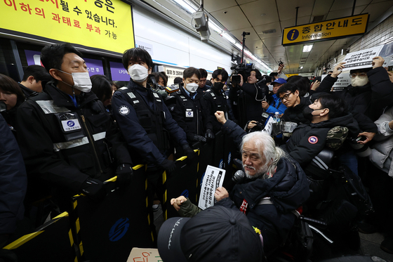 박경석 전국장애인차별철폐연대(전장연) 대표를 비롯한 전장연 관계자들이 서울 종로구 혜화역 승강장에서 열린 출근길 지하철 탑승 시위에서 관련 구호를 외치고 있다. 〈사진=연합뉴스〉