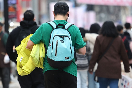 포근한 날씨를 보인 지난 4일 오후 서울 명동거리를 찾은 한 시민이 반팔 차림으로 걸어가고 있다. 〈사진=연합뉴스〉