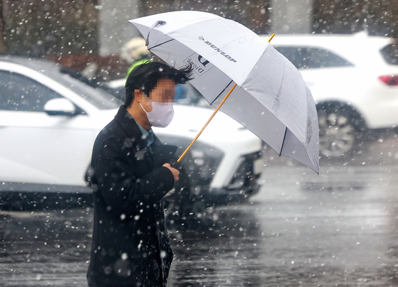 지난 15일 오후 눈이 내리는 서울 서초구 반포대로에서 한 시민이 우산을 쓴 채 걸어가고 있다. 〈사진=연합뉴스〉