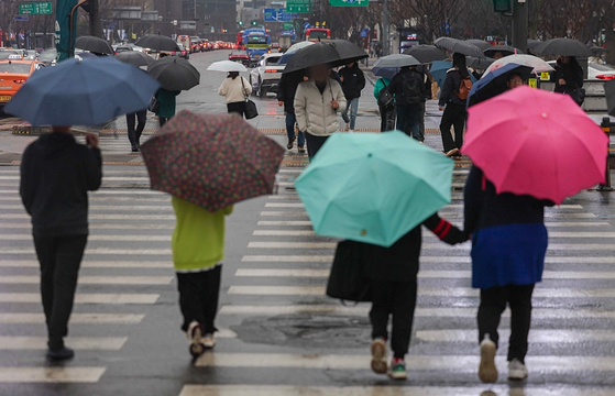 비가 내린 15일 오전 서울 종로구 광화문광장에서 우산을 쓴 시민들이 횡단보도를 건너고 있다. 〈사진=연합뉴스〉