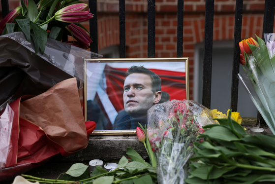 지난 17일 영국 런던 러시아 대사관 앞에 알렉세이 나발니의 초상화와 꽃이 남겨져 있다. 〈사진=로이터〉