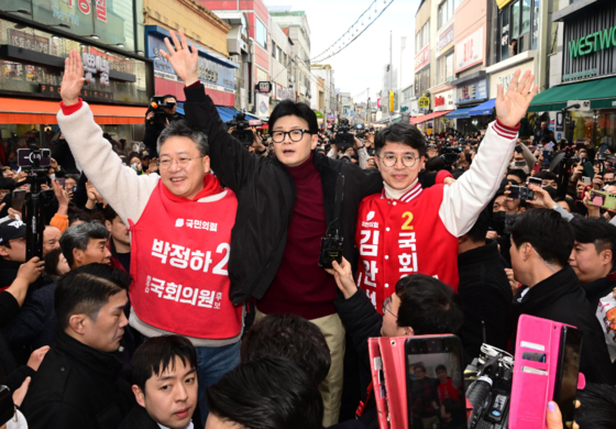 한동훈 국민의힘 비상대책위원장이 지난달 26일 강원 원주 중앙시장을 방문해 시민들을 향해 인사하고 있다. 왼쪽은 박정하 의원, 오른쪽은 김완섭 예비후보. 〈사진=공동취재〉