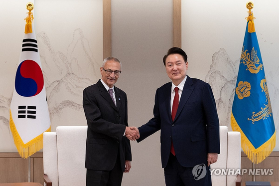 윤석열 대통령이 12일 서울 용산 대통령실 청사에서 존 포데스타 미국 대통령 국제기후정책 선임고문을 맞아 악수하고 있다.