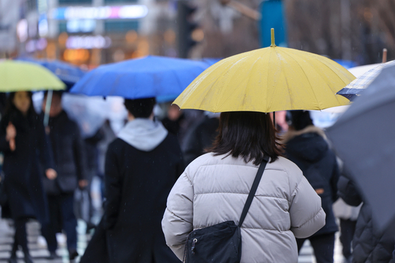 서울 광화문네거리에서 우산을 쓴 시민들이 횡단보도를 건너고 있다. 〈사진=연합뉴스〉
