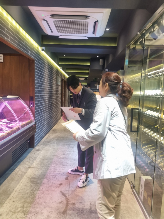 압구정 거리 식품접객업소에 공문을 전달하고 있는 강남구청 직원들. 〈사진=강남구〉 