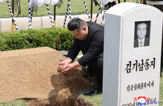 김기남 전 비서의 관 위에 흙을 뿌리는 김정은 국무위원장.