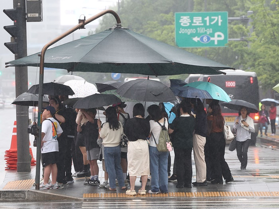 지난달 26일 오후 비가 내리는 서울 광화문광장에서 시민들이 우산을 쓴 채 보행신호를 기다리고 있다. 〈사진=연합뉴스〉