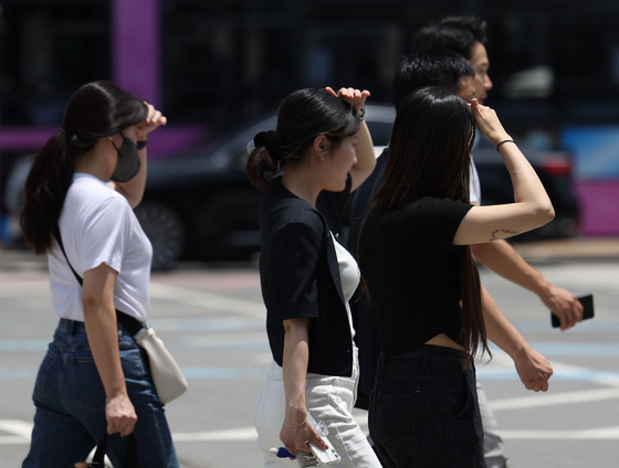 17일 서울 광화문사거리에서 시민들이 손으로 햇볕을 가리며 횡단보도를 건너고 있다. 〈사진=연합뉴스〉