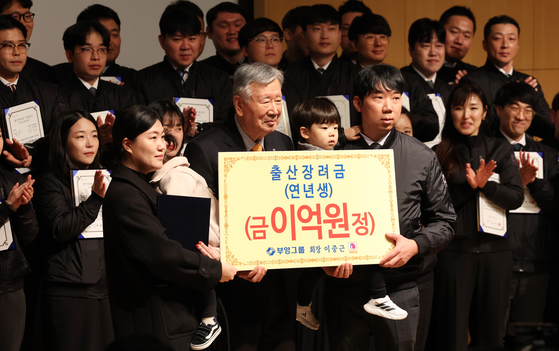 이중근 부영그룹 회장이 지난 2월 서울 중구 부영빌딩에서 열린 시무식에서 연년생 가족에게 출산장려금을 전달한 뒤 기념촬영을 하고 있다. 〈사진=연합뉴스〉