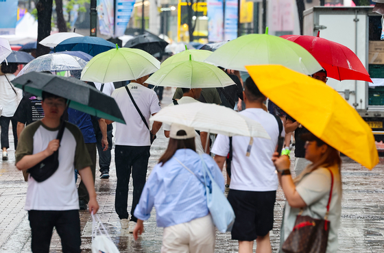 지난달 22일 오전 서울 명동거리에 시민들과 관광객들이 우산을 쓰고 이동하고 있다, 〈사진=연합뉴스〉