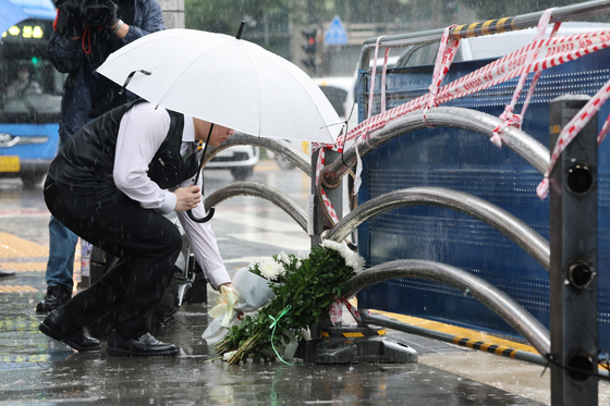 한 시민이 시청역 사고 현장에 마련된 추모 공간에서 국화꽃을 놓고 있다. 〈사진=연합뉴스〉