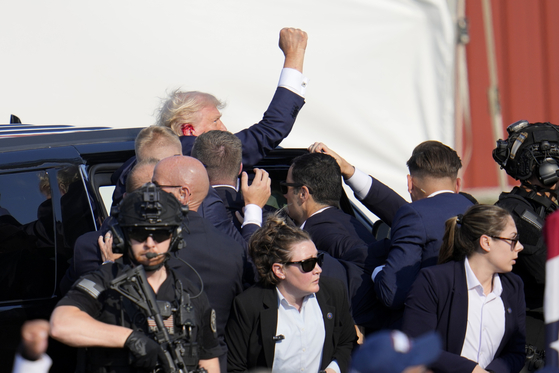 Republican presidential candidate former President Donald Trump is escorted to a motorcade following an attempted assassination at a campaign event in Butler, Pa., on Saturday, July 13, 2024. (AP Photo/Gene J. Puskar)