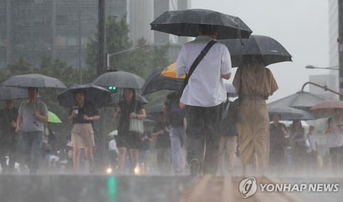 서울 지역에 호우경보가 내려진 17일 오전 서울 종로구 광화문광장 인근에서 시민들이 우산을 쓰고 이동하고 있다. 〈사진=연합뉴스〉