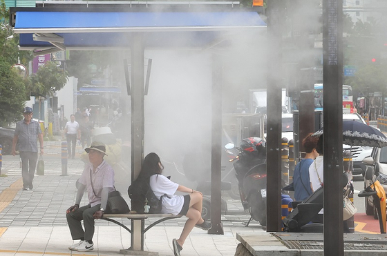 부산 동구 부산진역 앞 횡단보도 인근에 시민들이 쿨링포그(인공안개 분사시설) 아래에서 더위를 식히고 있다. 〈사진=연합뉴스〉