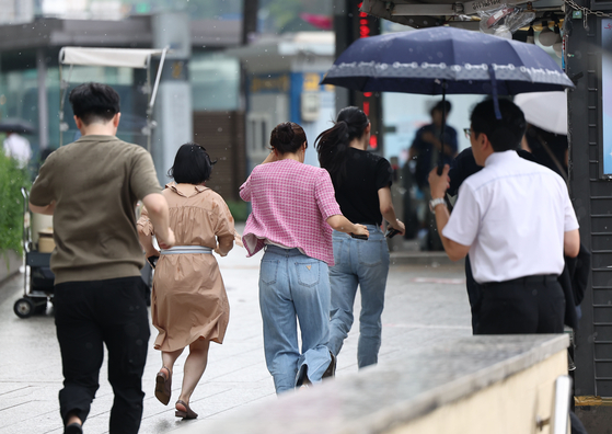 지난 5일 서울 중구 한국은행 앞 사거리에서 시민들이 소나기를 피하고 있다. 〈사진=연합뉴스〉