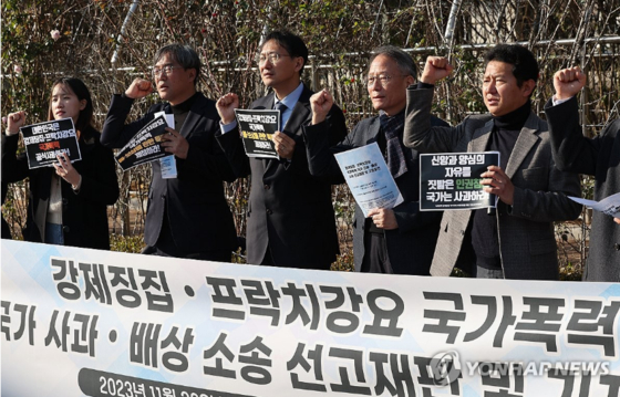  전두환 정권 시절 고문을 받고 프락치(신분을 속이고 활동하는 정보원) 활동을 강요당한 피해자 박만규 목사(오른쪽 두번째)가 지난해 11월 22일 오후 서울 서초구 서울중앙지법에서 국가를 상대로 낸 손해배상 소송 선고공판을 마친 뒤 열린 기자회견에서 구호를 외치고 있다. 〈사진=연합뉴스〉 