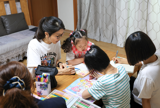 김건희 여사가 추석 연휴인 15일 서울 은평구 장애아동거주시설인 다움장애아동지원센터를 방문해 보조 교사와 함께 아이들이 그림책에 색연필로 색칠하는 것을 도와주고 있다. 〈사진=대통령실 제공/연합뉴스〉